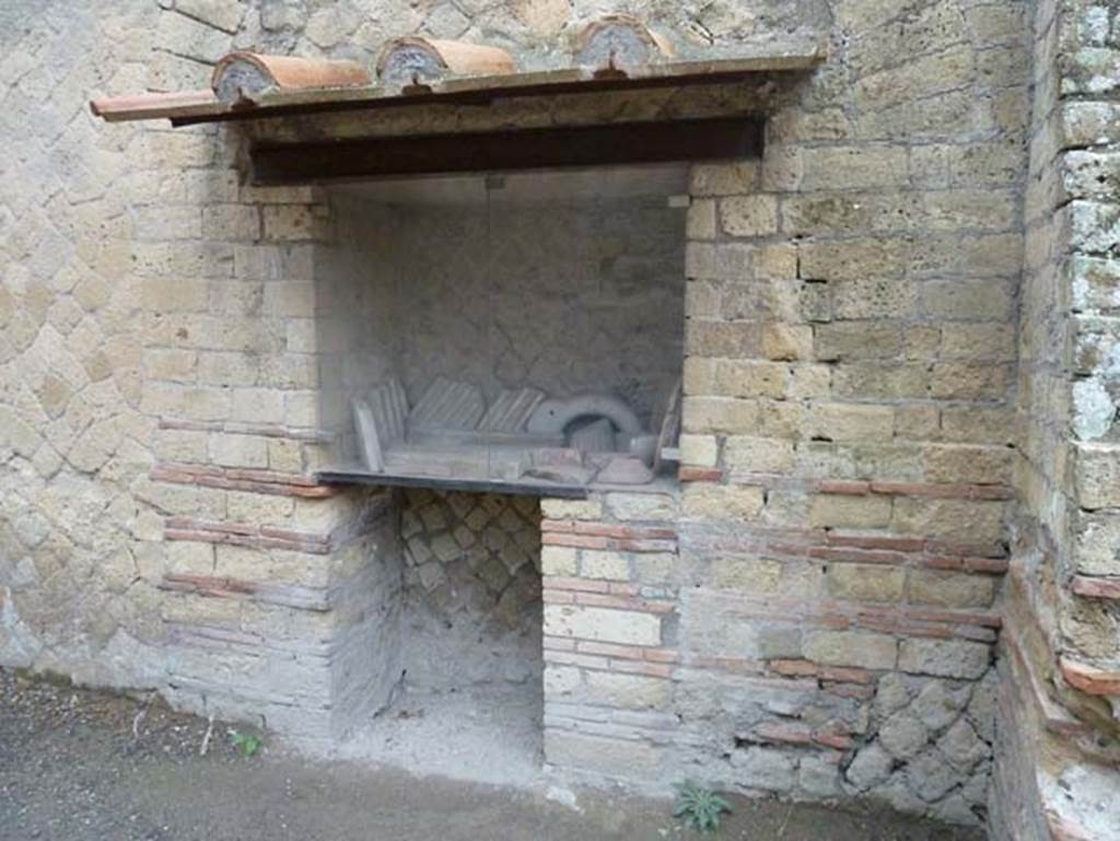 Ins. Orientalis II.5, Herculaneum. September 2015. Recess in south wall of workshop.
Camardo and Notomista wrote that placed inside the glass fronted recess with a wooden shelf were originally finds from the excavation. In the original list were included – glass, bronze, iron and ceramic objects, whereas today there are some marble finds.
See Camardo, D, and Notomista, M, eds. (2017). Ercolano: 1927-1961. L’impresa archeologico di Amedeo Maiuri e l’esperimento della citta museo. Rome, L’Erma di Bretschneider, (p.269, Scheda 46).